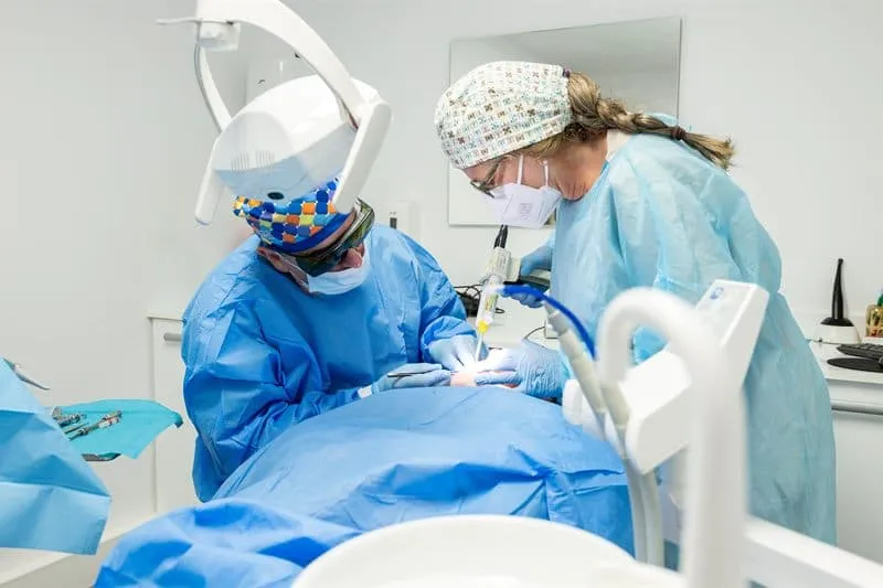 Dos profesionales de las Clínicas Dentales Francisco Hernández Vallejo realizando un tratamiento periodontal